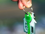 a-hand-holding-a-green-key-to-a-house.jpg A hand holding a green key to a house